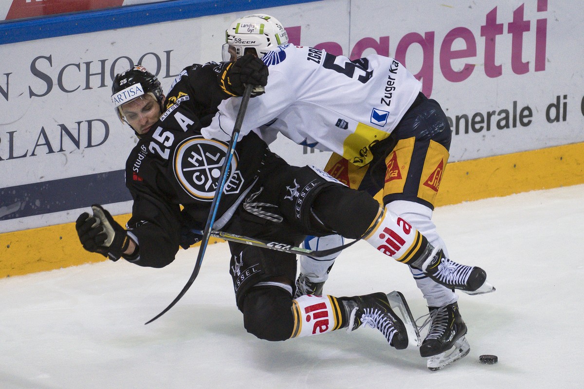 From left, Lugano's player Maxim Lapierre and Zug's player Jesse Zgraggen, during the preliminary round game of National League Swiss Championship 2018/19 between HC Lugano and EV Zugo, at t ...