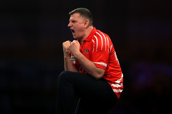 Poland's Krzysztof Ratajski celebrates victory against England's Luke Woodhouse on day seventeen of the World Darts Championship at the Alexandra Palace in London, Tuesday Dec. 30, 2025. (St ...