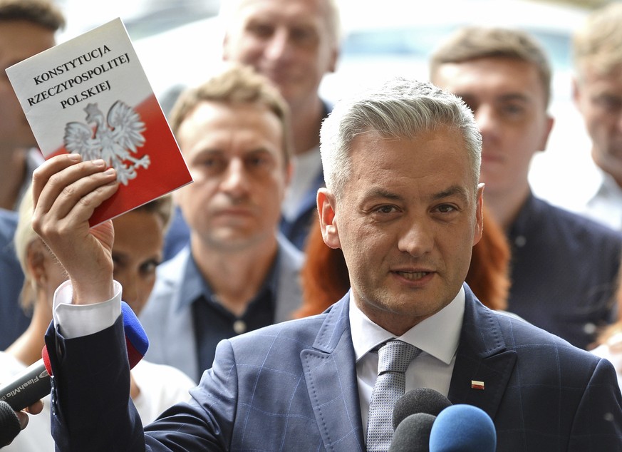 Poland&#039;s most prominent gay politician Robert Biedron holds a copy of the country&#039;s constitution as he announces a start of his new political movement during a press conference in Warsaw, Po ...