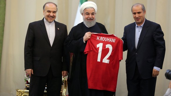epa06752452 A handout photo made available by the Presidential office shows Iranian President Hassan Rouhani (C) poses with the team's away jersey, in the presence of Iranian Football Federation  ...