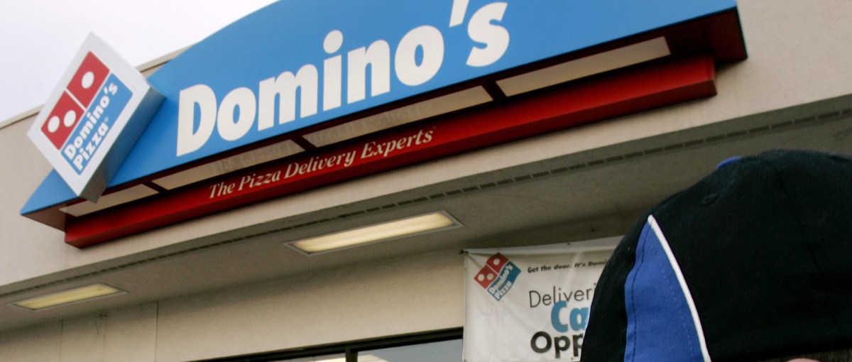 FILE - In this Feb. 21, 2007 file photo, Domino's Pizza delivery person Brandon Christensen plugs in the company sign atop his car in Sandy, Utah. The pizza delivery chain on Monday, June 16, 201 ...