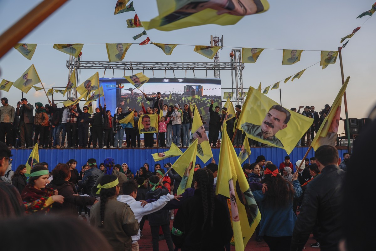 Kurdish residents hold flags showing Abdullah Ocalan as they attend a gathering to see live a Pro-Kurdish Peoples' Equality and Democracy Party, or DEM, delegation members releasing an statement  ...