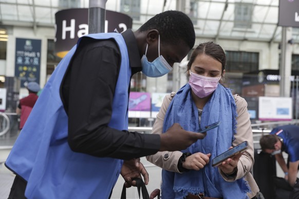 A railway employee checks the COVID-19 health pass that everyone in the country needs to enter cafes, trains and other venues, Monday Aug.9, 2021 at the Gare de Lyon train station in Paris. Starting t ...