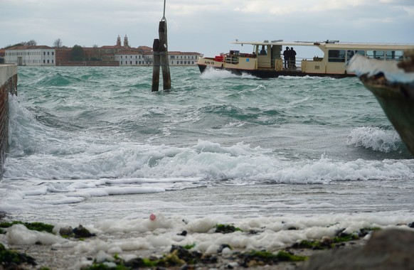 epa10286180 A public transport vaporetto sails in the lagoon south of Venice, off the island of San Servolo, while the strong wind from the south creates large waves that make it difficult ...