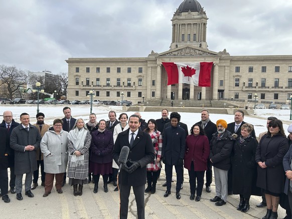 Premier Wab Kinew and members of his NDP caucus outside the legislative building hold a press conference in Winnipeg on Tuesday March 4, 2025. (Steve Lambert/The Canadian Press via AP)
Canada-Trump-Ta ...