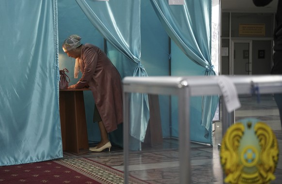 A woman fills in her ballot at a polling station during the Nationwide Referendum in Nur-Sultan, Kazakhstan, Sunday, June 5, 2022. Kazakhs vote on a package of reforms intended to transform the countr ...