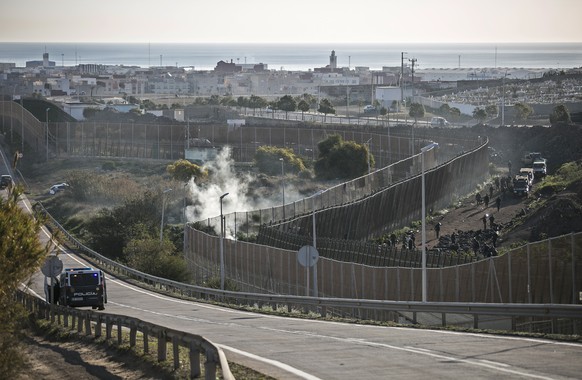 Security forces on the Moroccan side of the border force migrants to lie down in front of the fence after stopping them crossing the fences separating the Spanish enclave of Melilla from Morocco, in M ...