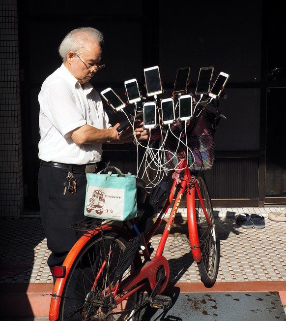 epa06935285 Chen San-yuan, a 59-year-old Feng Shui Master,leaves home with 11 cellphones and a bag of batteries to catch Pokemon in New Taipei City, Taiwan, 08 August 2018. Chen was hooked on Pokemon  ...