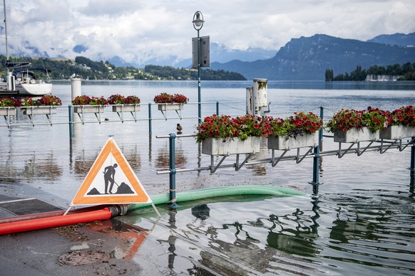 epa09348953 The water overflows at Schweizerhofquai in Lucerne, Switzerland, 16 July 2021. The water level of Lake Vierwaldstaettersee has risen ominously high and flooding is expected in the next few ...