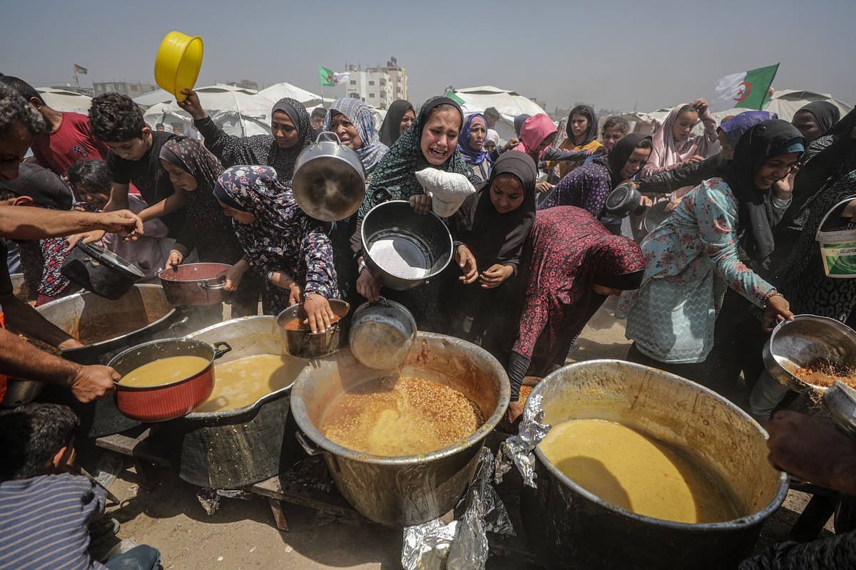 epa12086659 Internally displaced Palestinians gather to receive a portion of food from a charity kitchen, in Jabalia refugee camp, northern Gaza Strip, 09 May 2025. According to the UN Palestinian ref ...