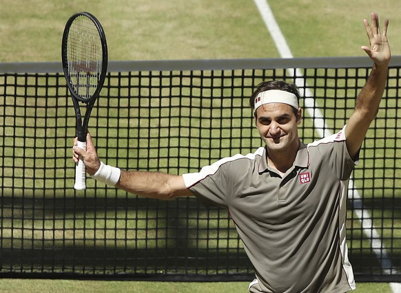 Swiss Roger Federer celebrates after winning the tennis ATP final against Belgium David Goffin in Halle, Germany, Sunday, June 23, 2019. (Friso Gentsch/dpa via AP)