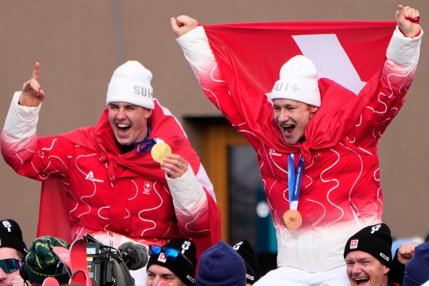Switzerland's Franjo von Allmen, gold medalist in an alpine ski, men's super-G race, left, celebrates with bronze medalist Switzerland's Marco Odermatt, at the 2026 Winter Olympics, in  ...