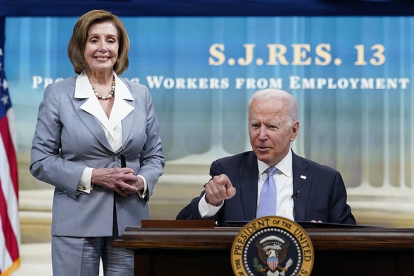 President Joe Biden, joined by House Speaker Nancy Pelosi of Calif., talks in-between signing signs several bills during an event in the South Court Auditorium on the White House complex in Washington ...