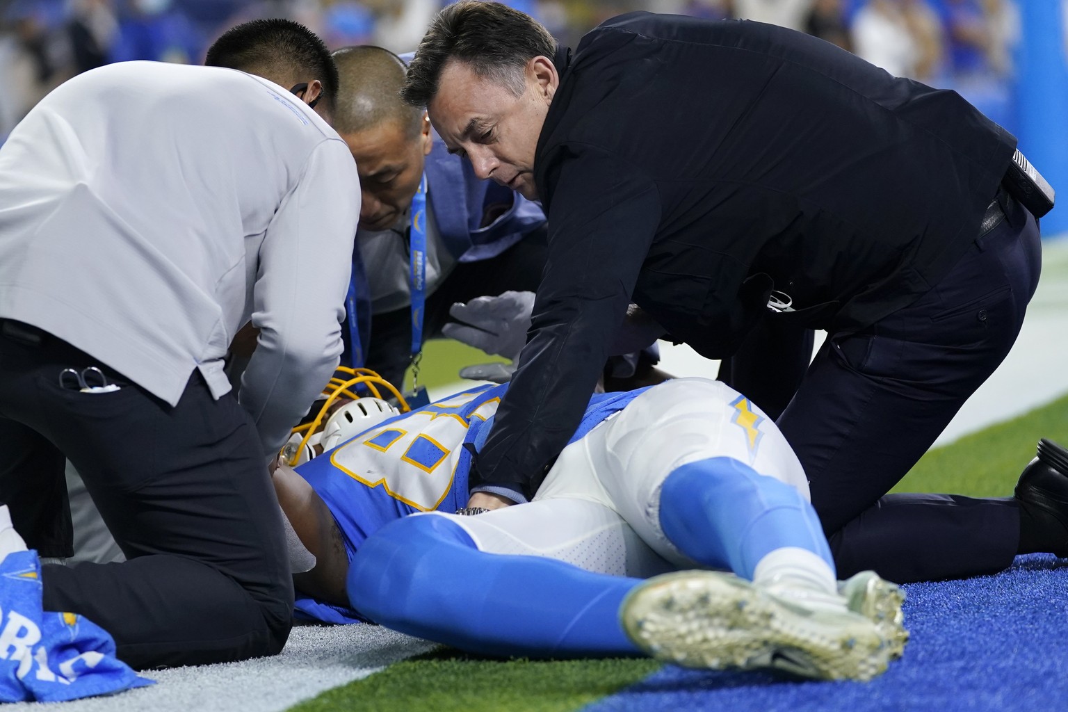 Team officials attend to Los Angeles Chargers tight end Donald Parham as he stays down after an injury during the first half of an NFL football game against the Kansas City Chiefs, Thursday, Dec. 16,  ...