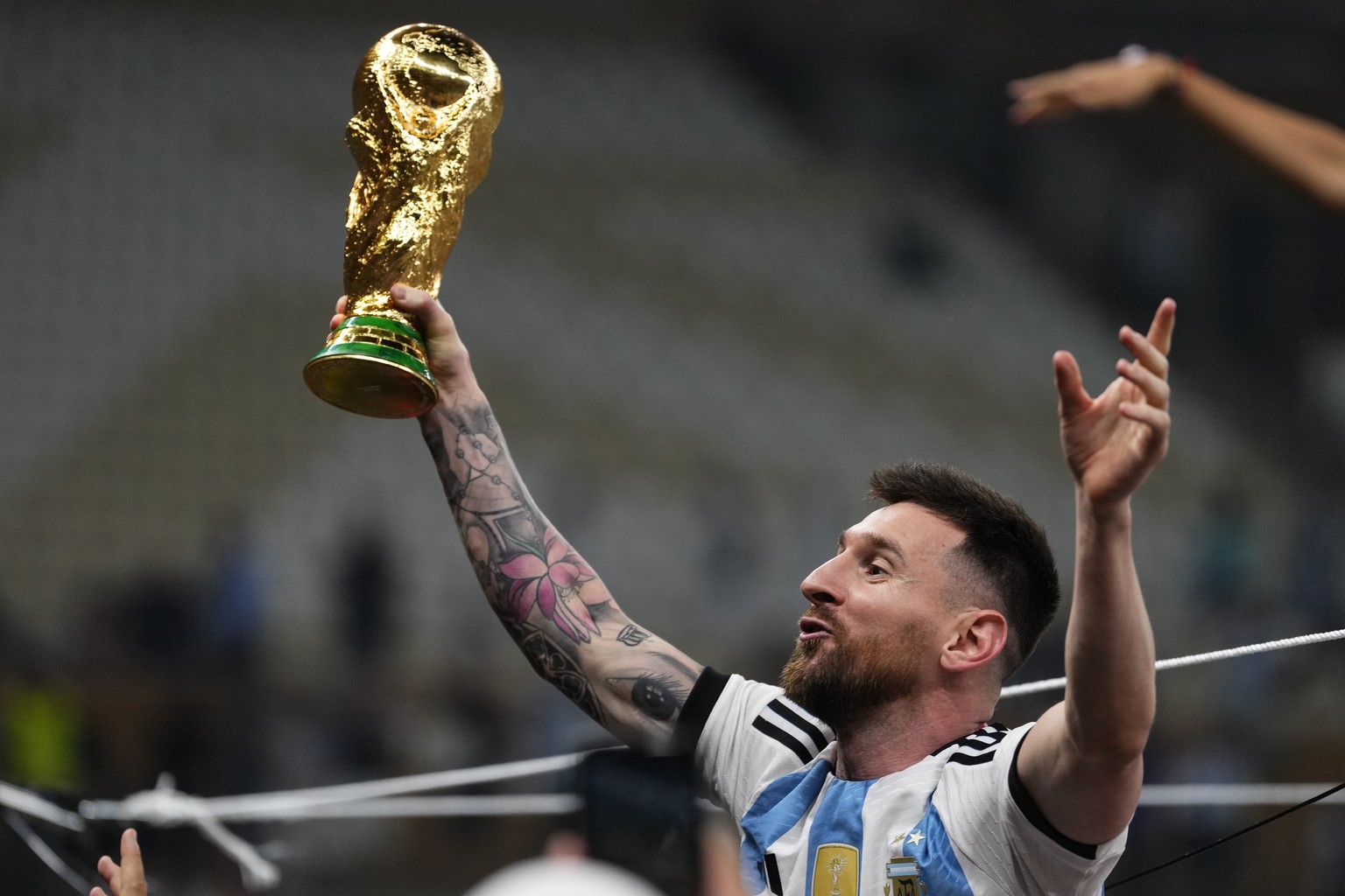 Argentina&#039;s Lionel Messi celebrates with the trophy after winning the World Cup final soccer match between Argentina and France at the Lusail Stadium in Lusail, Qatar, Sunday, Dec.18, 2022. (AP P ...