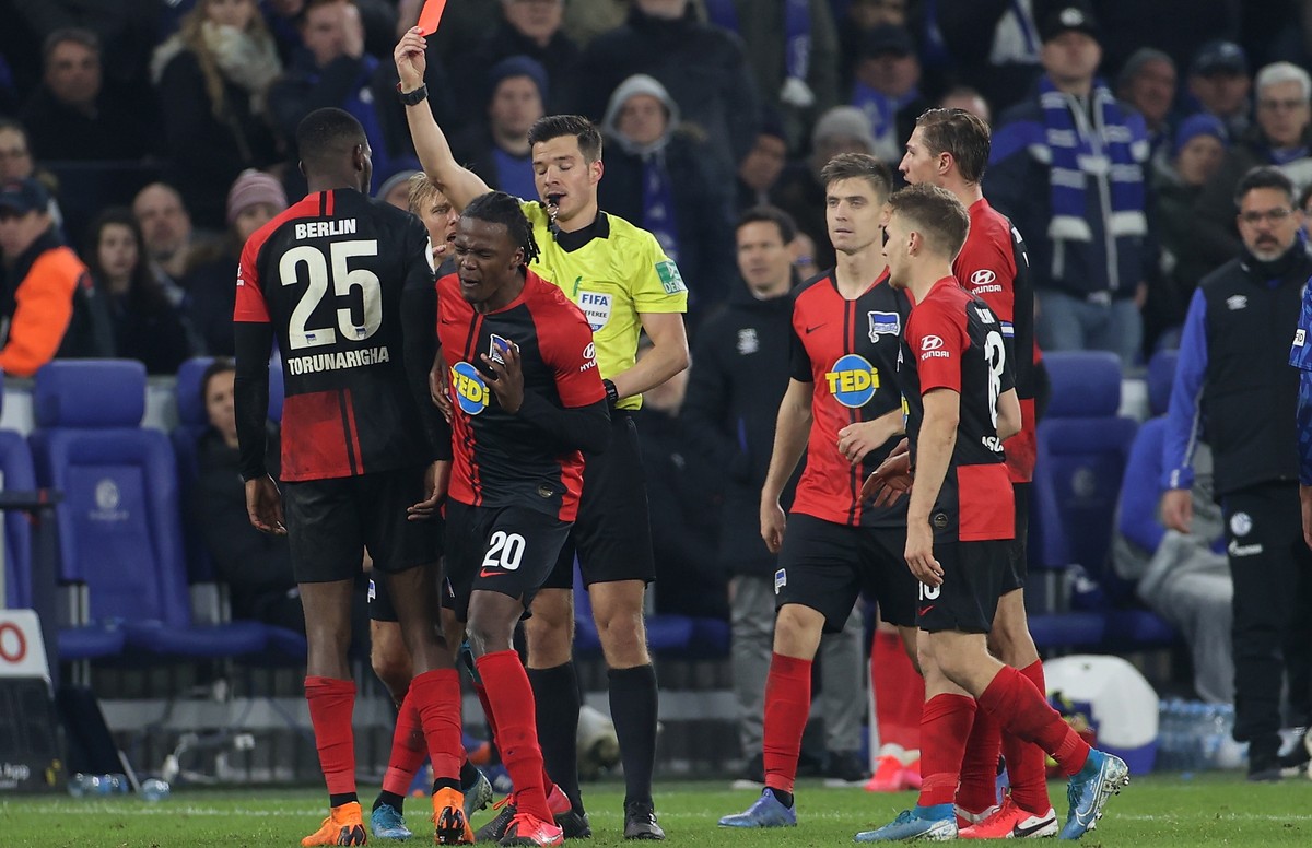 epa08193208 Referee Harm Osmers (C) shows Hertha's Jordan Torunarigha (L) the red card during the German DFB Cup round of sixteen soccer match between Schalke 04 and Hertha BSC Berlin in Gelsenki ...