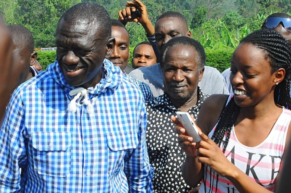 Oppositionsführer&nbsp;Kizza Besigiye spricht nach der Stimmabgabe mit Unterstützern: Der aussichtsreichste Rivale des amtierenden Präsidenten war mehrmals festgenommen worden. &nbsp;