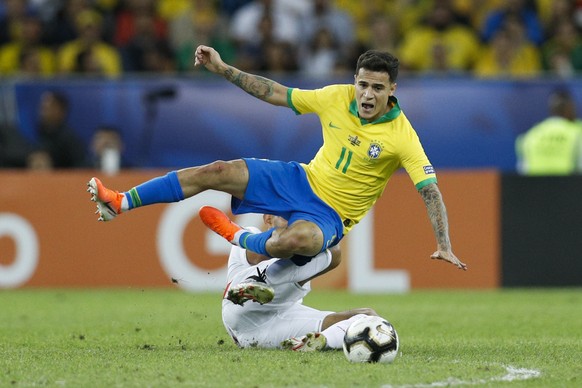 Brazil's Philippe Coutinho falls over Peru's Carlos Zambrano during the final soccer match of the Copa America at the Maracana stadium in Rio de Janeiro, Brazil, Sunday, July 7, 2019. (AP Photo/Victor ...