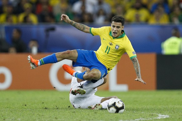 Brazil&#039;s Philippe Coutinho falls over Peru&#039;s Carlos Zambrano during the final soccer match of the Copa America at the Maracana stadium in Rio de Janeiro, Brazil, Sunday, July 7, 2019. (AP Ph ...