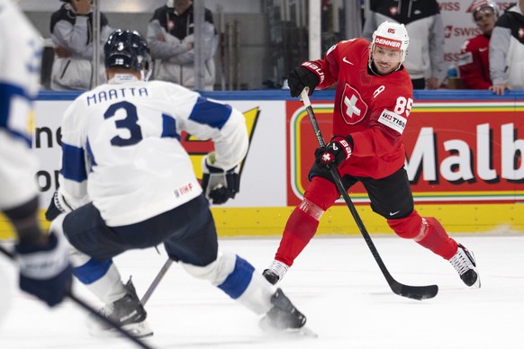 epa12996005 Switzerland's Sven Andrighetto, right, shoots the puck against Finland's Olli Maatta, left, during the 2026 IIHF Men's Ice Hockey World Championship preliminary round group  ...