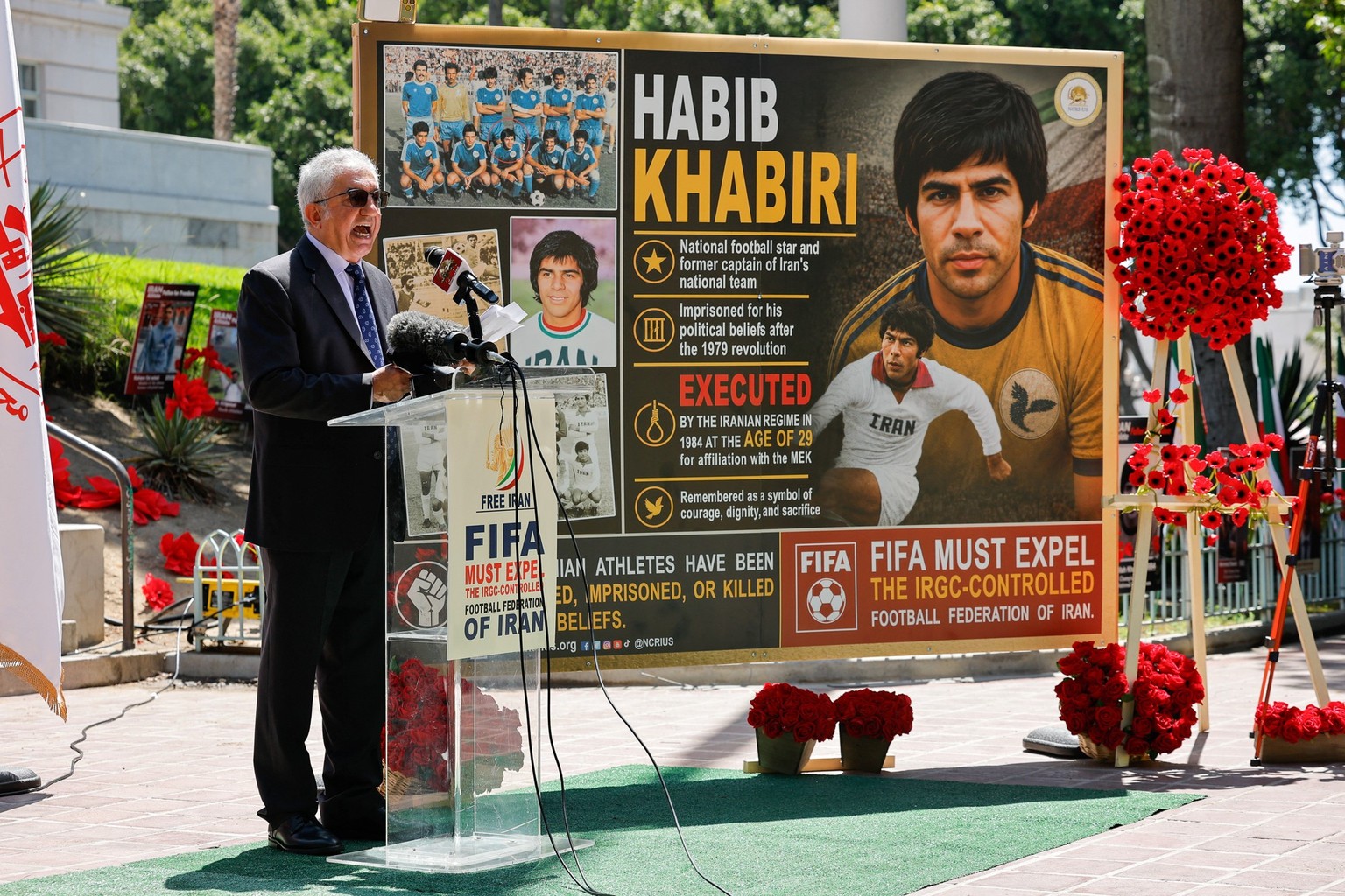 Hamid Azimi member of National Council of Resistance of Iran (NCRI) speaks near an image of former Iranian soccer player Habib Khabiri, as the NCRI holds a political advocacy press conference calling  ...