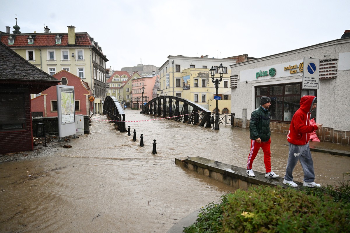 epa11605256 People pass by next to a flooded street after the heavy rainfalls caused the flooding in Klodzko, southwestern Poland, 15 September 2024. The next 24-36 hours will be crucial for the south ...