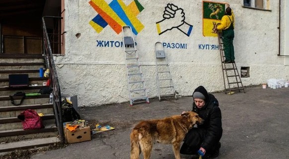 Das Leben kommt langsam zurück nach Kupjansk: Künstler bemalen die Fassade des Rathauses.