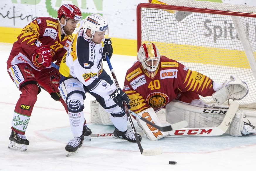 Tigers, Anthony Huguenin, links, und Goalie, Damiano Ciaccio, kaempfen um den Puck, gegen Ambris, Dario Rohrbach, Mitte, waehrend dem Meisterschaftsspiel der National League, zwischen den SCL Tigers u ...