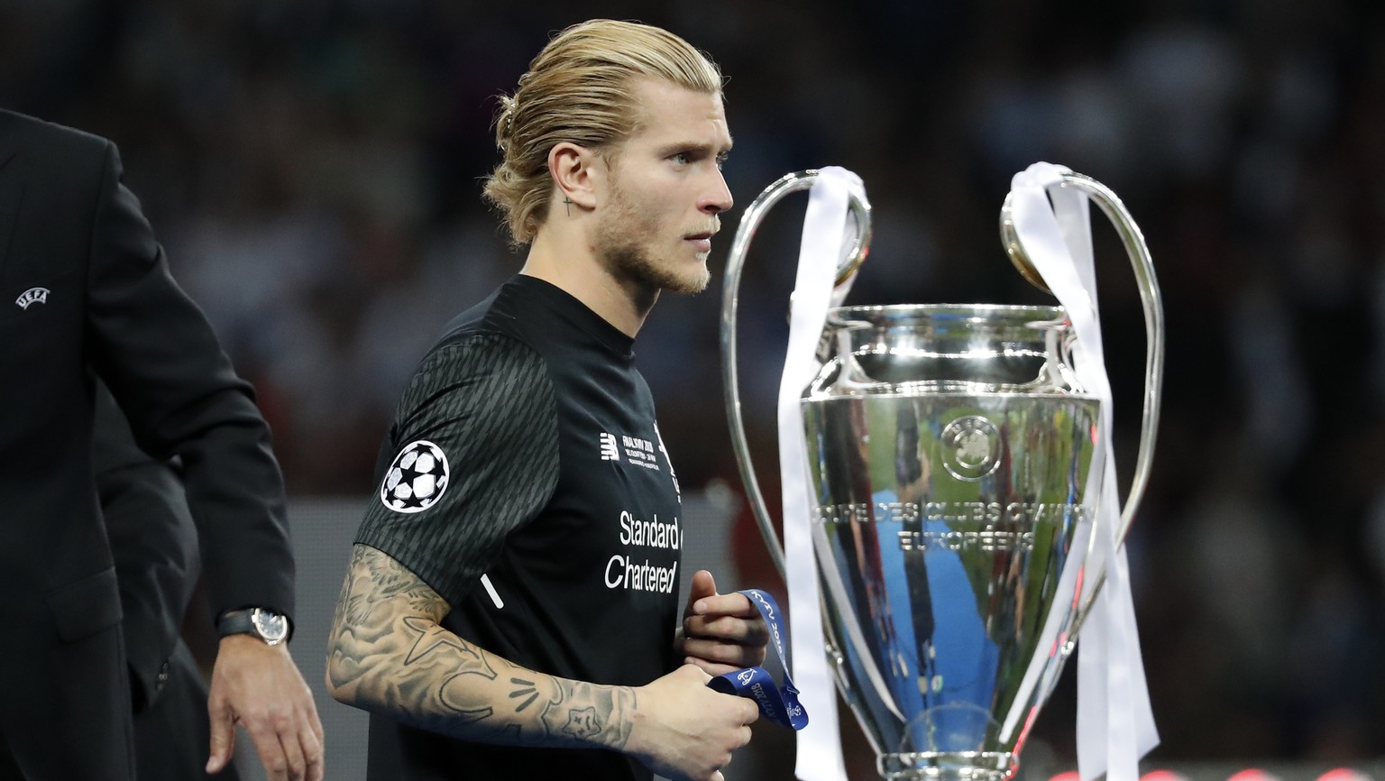 Liverpool goalkeeper Loris Karius walks past the trophy after the Champions League Final soccer match between Real Madrid and Liverpool at the Olimpiyskiy Stadium in Kiev, Ukraine, Saturday, May 26, 2 ...