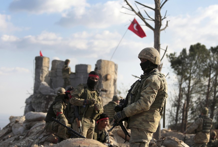 Pro-Turkey Syrian fighters and Turkish troops secure the Bursayah hill, which separates the Kurdish-held enclave of Afrin from the Turkey-controlled town of Azaz, Syria, Sunday, Jan. 28, 2018. Turkish ...