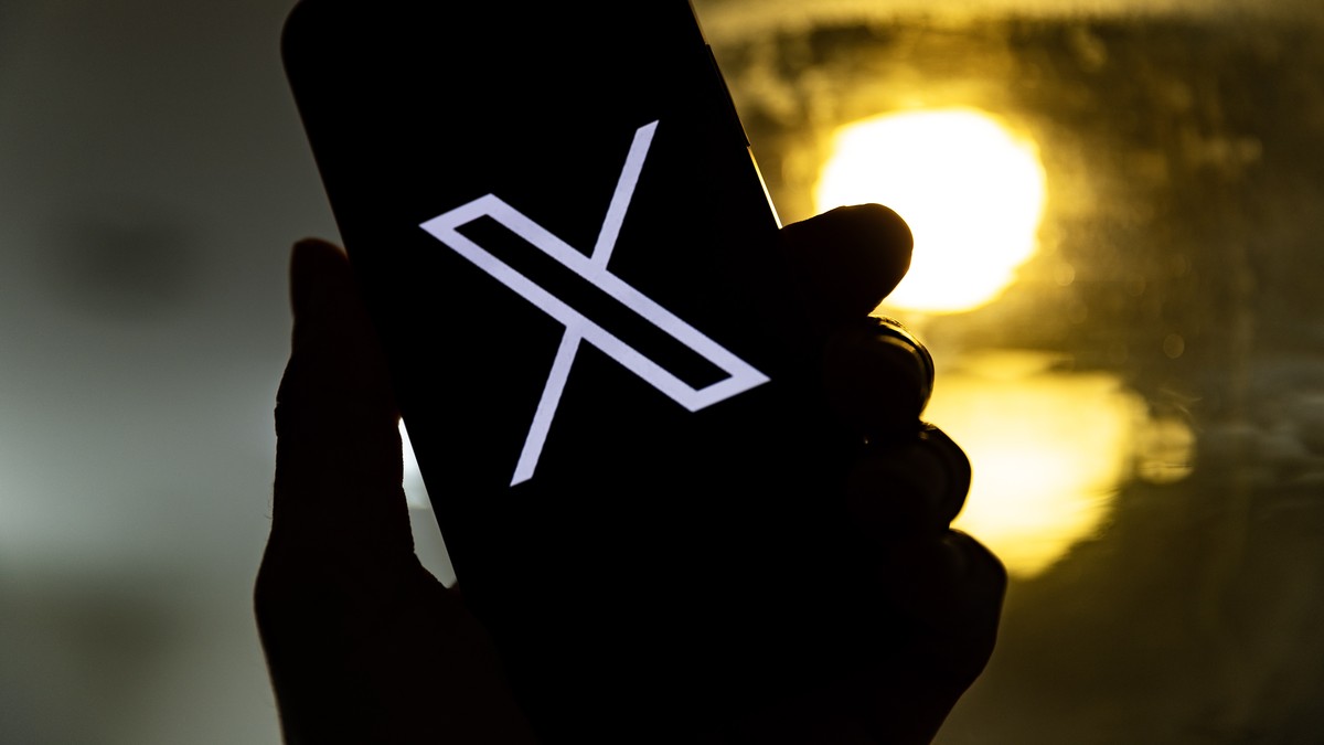 epa10772440 An illustration pictures shows a user holding a mobile phone displaying the 'X' logo, in Los Angeles, California, USA, 27 July 2023. Twitter announced on 23 July that it will reb ...