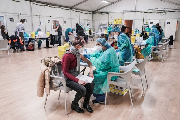 epa09680388 Health staff administers anti-Covid-19 vaccines at the Valentino hub in Turin, Italy, 12 January 2022. The Piedmont region for the first time administered more than 50,000 Covid19 vaccine  ...