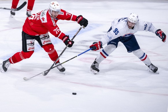 Switzerland&#039;s Tino Kessler, left, against France&#039;s Kevin Bozon, right, during an ice hockey World Cup preparation match between Switzerland and France at the St. Jakob-Arena in Basel, Switze ...