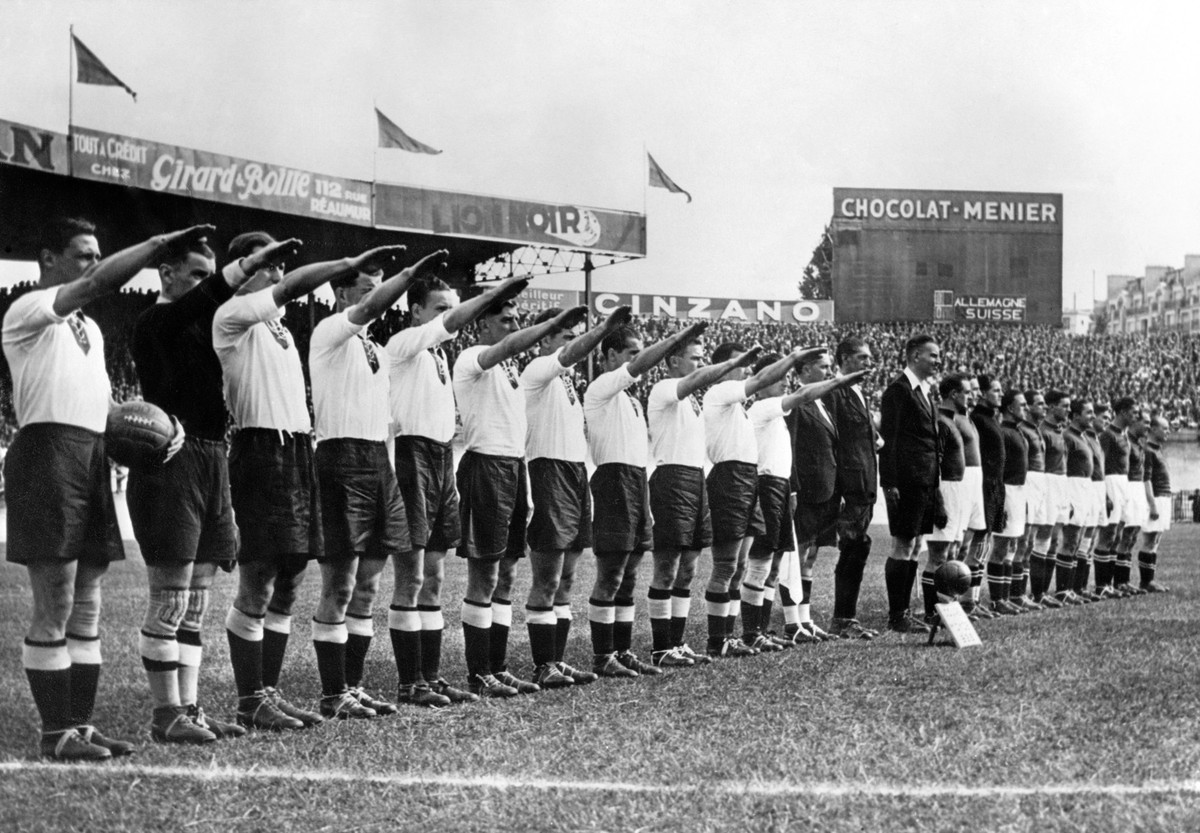 Die Mannschaften Deutschlands und der Schweiz vor ihrer Begegnung an der Fussball-Weltmeisterschaft im Juni 1938 im Stadion "Parc des Princes" in Paris, Frankreich. Links mit erhobenem Arm d ...