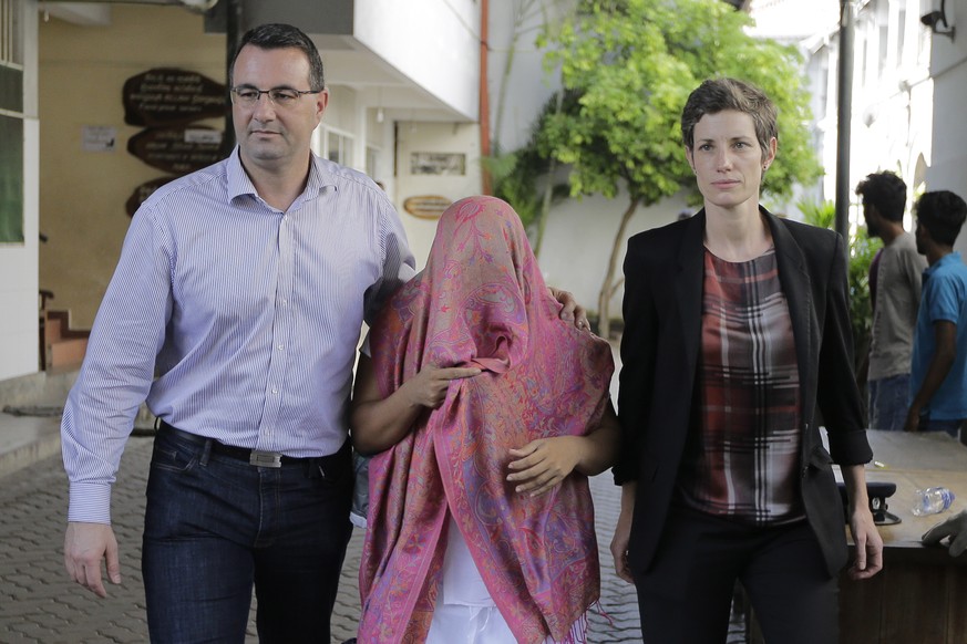 epa08094783 Swiss embassy personnel accompany staff member Garnier Banister Francis (C) out of the court premises after she was granted bail in Colombo, Sri Lanka, 30 December 2019. A female staffer o ...
