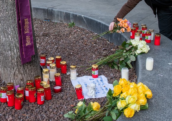 08.12.2019, Bayern, Augsburg: Am Königsplatz legt eine Frau Blumen nieder. Ein Feuerwehrmann war am Abend des 06.12.2019 in seiner Freizeit hier in einer Auseinandersetzung mit einer Gruppe so schwer  ...