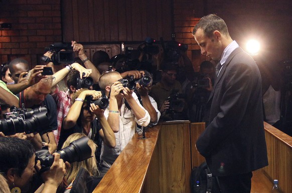 FILE - In this Friday, Feb 22, 2013 file photo photographers take photos of Olympic athlete Oscar Pistorius as he appears at a bail hearing for the shooting death of his girlfriend Reeva Steenkamp, in ...