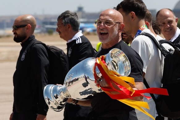 epa11479926 Spain's head coach Luis de la Fuente carries the trophy upon their arrival at Adolfo Suarez Madrid-Barajas airport, in Madrid, Spain, 15 July 2024. Spain defeated England by 2-1 in th ...