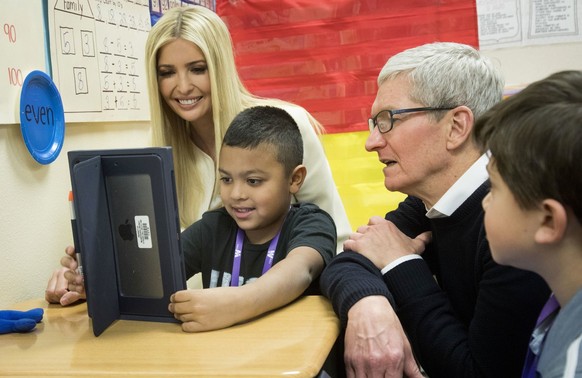 Apple CEO Tim Cook, right, and Ivanka Trump, daughter and advisor to President Donald Trump, talk with first-grader Israel Perez about work he&#039;s doing on his iPad during a visit to Wilder Element ...