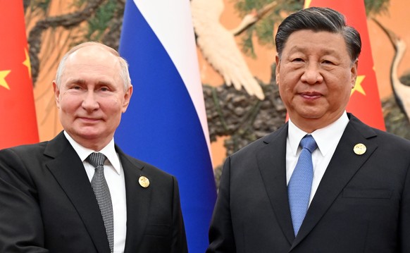 epa10924847 Russian President Vladimir Putin (L) and Chinese President Xi Jinping shake hands before their meeting as part of the 3rd Belt and Road Forum for International Cooperation, at the Great Ha ...