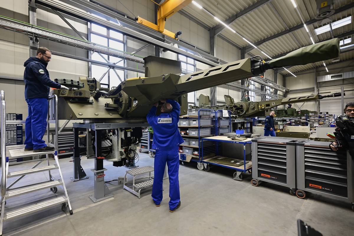 epa11147829 Employees work at a production line as German chancellor and defence minister visit a production line at the future site of an arms factory where weapons maker Rheinmetall plans to produce ...