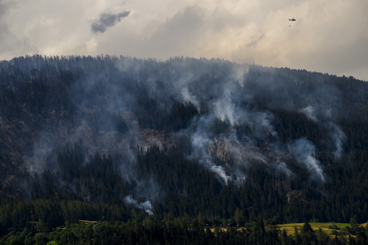 Un helicoptere Super Puma verse de l'eau sur la fumee qui s'echappe de la foret en feu au dessus des communes de Bitsch et Ried-Moerel le mardi 18 juillet 2023 depuis Termen. Les h