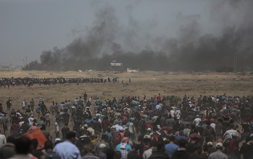 epa06736295 Hundreds of Palestinian protesters gather during clashes after protests near the border with Israel in the east of Gaza Strip, 14 May 2018. According to media reports, at least 50 Palestin ...