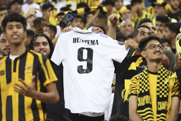 Al Ittihad soccer fans wave a shirt of their team player Karim Benzema during a presentation ceremony at King Abdullah Sports City Stadium in Jeddah, Saudi Arabia, Thursday, June 8, 2023. Benzema, who ...