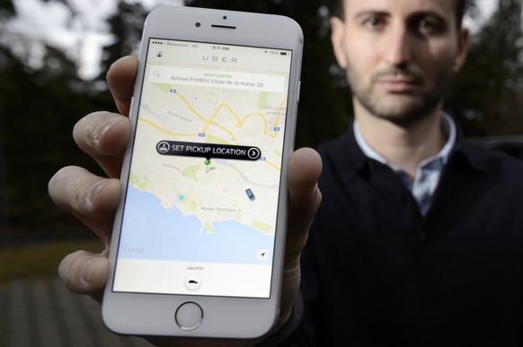 Steve Salom, General Manager d&#039; Uber en Suisse romande pose avec son telephone portable et l&#039; app Uber devant une voiture lors d&#039;une conference de presse sur l&#039;annonce de l&#039;ar ...