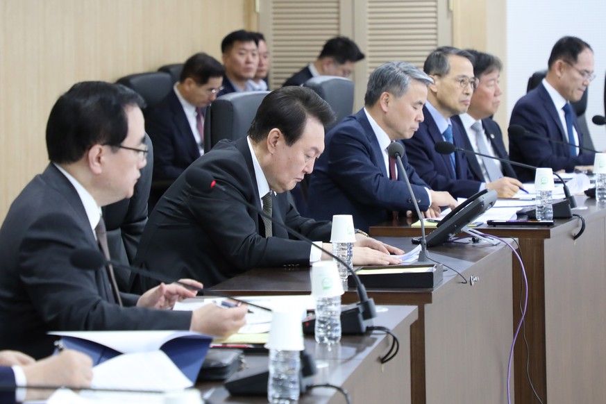 epa10525300 A handout photo made available by the South Korean presidential office shows South Korean..President Yoon Suk Yeol (2nd from L) attending an emergency National Security Council meeting at  ...