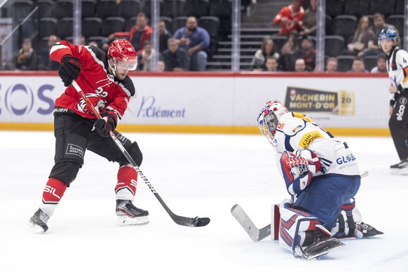 L&#039;attaquant lausannois Miikka Salomaeki, gauche, lutte pour le puck avec le gardien zurichois Juha Metsola, droite, lors du match du championnat suisse de hockey sur glace de National League entr ...