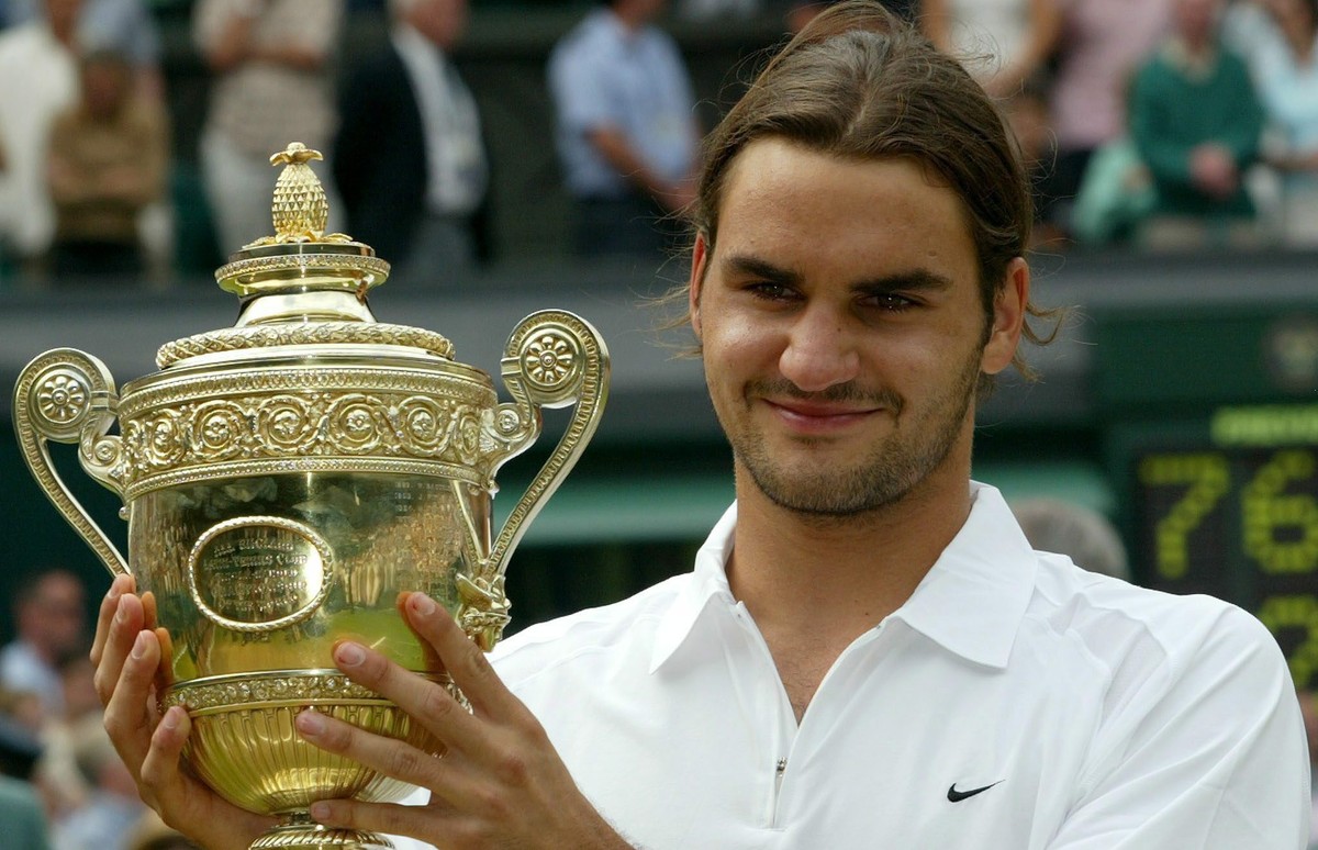 epa10185790 (FILE) - Swiss Roger Federer holds the trophy after winning the Men's Final against Mark Philippoussis of Australia at the All England Lawn Tennis Championships in Wimbledon, Sunday 0 ...