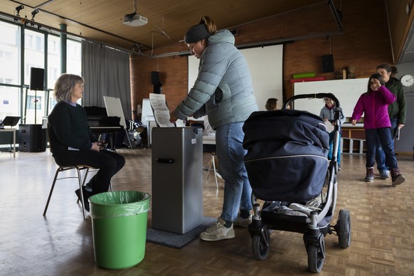 Eine Stimmbuergerin wirft ihren Stimmzettel in die Urne, im Stimmlokal Schulhaus Hochfeld, am Samstag, 2. Maerz 2024 in Bern. Die Schweizer Buergerinnen und Buerger stimmen ueber die Renteninitiative  ...