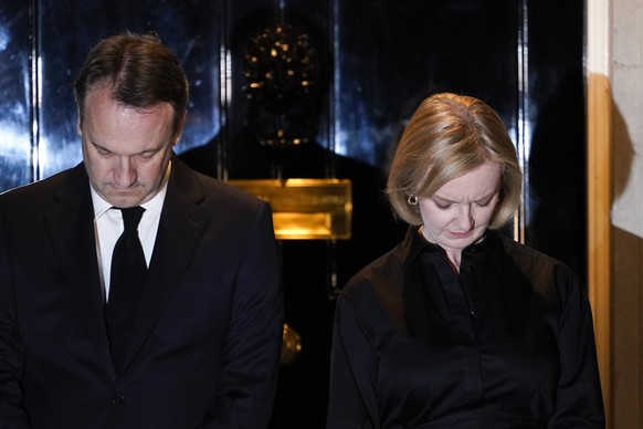 Britain&#039;s Prime Minister Liz Truss, right, and her husband Hugh O&#039;Leary observe a minute silence outside 10 Downing Street, in London, Sunday, Sept. 18, 2022, ahead of tomorrow&#039;s funera ...